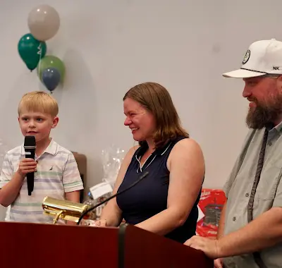 A family sharing a moment at the podium during the 2026 benefit program